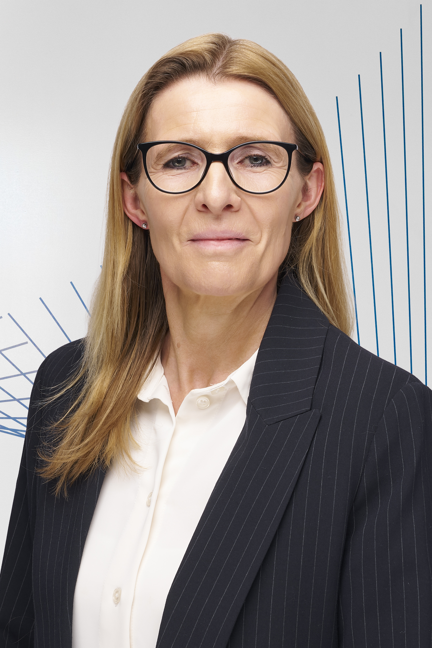 A blond woman wearing glasses wearing a suit.