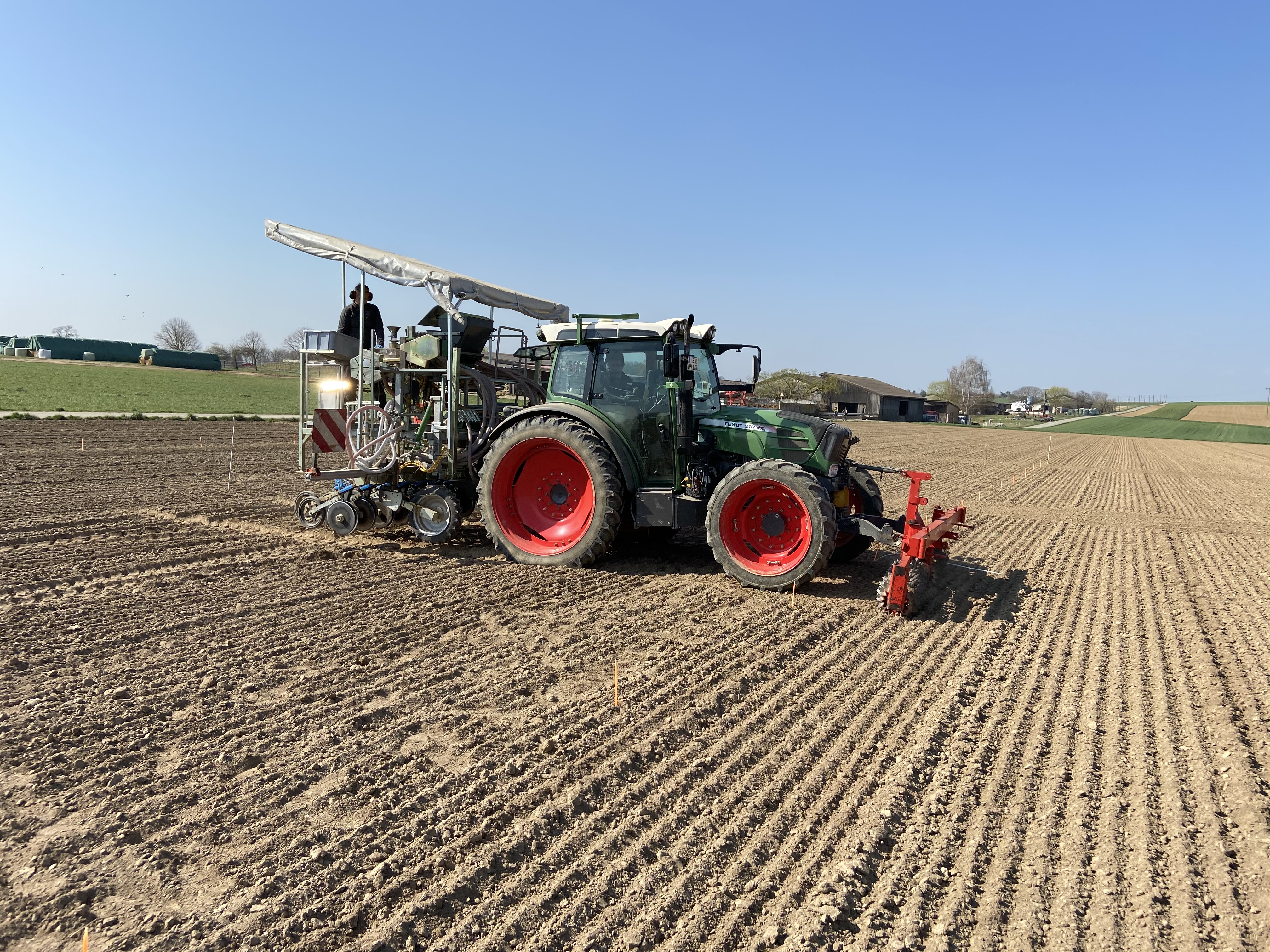 Ein Traktor bei der Aussaat des Linsen-Stützfrucht-Gemenge auf einem Feld des Ihinger Hofes bei Renningen.