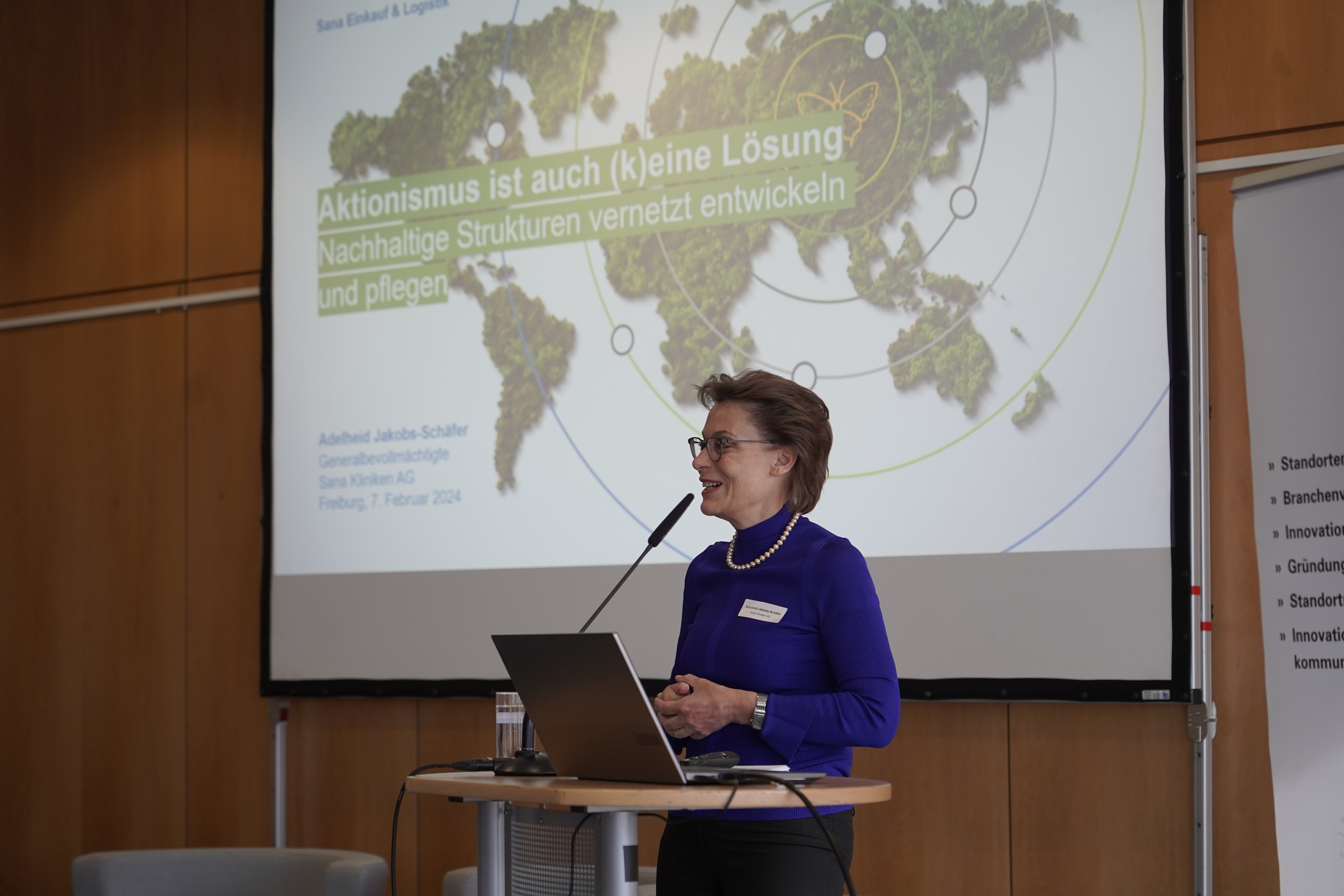 Keynote-Sprecherin Adelheid Jakobs-Schäfer steht am Rednerpult, hinter ihr ist die Präsentationsfolien mit dem Titel der Keynote zu sehen: 