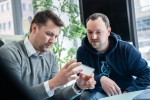 The two founders sitting, looking at the new SpecPlate microtitre plate.