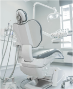 Ein weißer Zahnarztstuhl mit verschiedenen Dentalinstrumenten.