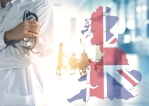 Teaser image intended to represent the National Health Service in the UK. It shows the upper body of a doctor, with a hospital corridor in the background. To the right of the doctor is the slightly transparent outline of the British flag in the shape of Great Britain.